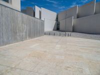 the gray concrete walls of a building have a line of steps on the left side