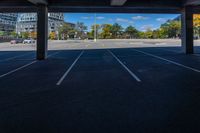 empty parking space under an overpass with a blue sky background, with the sun shining through the clouds