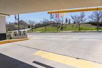 a parking garage area with an open area and signage on the ground next to an asphalt road