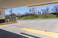 a parking garage area with an open area and signage on the ground next to an asphalt road