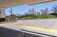 a parking garage area with an open area and signage on the ground next to an asphalt road