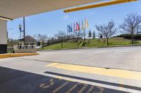 a parking garage area with an open area and signage on the ground next to an asphalt road