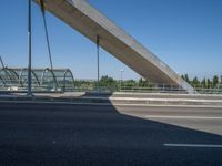 a truck driving across a bridge near a street corner near buildings and a bridge with many cables