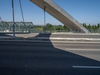 a truck driving across a bridge near a street corner near buildings and a bridge with many cables