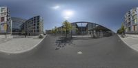 a 360 - ball photo of some buildings near a street corner and a fence with trees