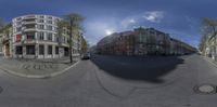 a fish eye view of two streets with cars driving on the road and buildings on the side