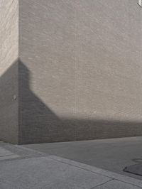 a side street view of the exterior of a building, looking up at the shadow of a wall