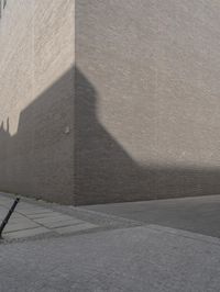 a side street view of the exterior of a building, looking up at the shadow of a wall