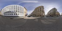 a view from a fisheye of city street with buildings and bicycles on it and a person riding a bike