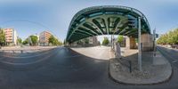 a 360 - view photo of an overhead street and roadway intersection under a bridge and street signs