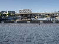 a view of a bridge over water and some buildings in the background with a blue sky