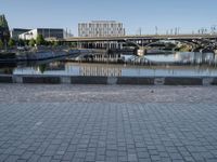 a view of a bridge over water and some buildings in the background with a blue sky