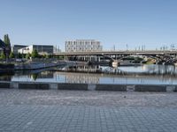 a view of a bridge over water and some buildings in the background with a blue sky