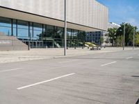 a woman is walking by the modern building on the street with skateboards in hand