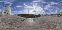 a fisheye lens shot of a plaza and buildings in the city park at sunny day