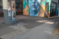 a woman is in the corner near a street sign and a painting on the side wall