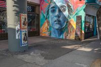 a woman is in the corner near a street sign and a painting on the side wall