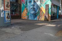 a woman is in the corner near a street sign and a painting on the side wall