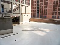 a white concrete floor in an empty room by a building with red bricks and a ramp