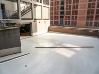 a white concrete floor in an empty room by a building with red bricks and a ramp