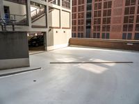 a white concrete floor in an empty room by a building with red bricks and a ramp