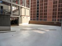 a white concrete floor in an empty room by a building with red bricks and a ramp