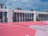 pink parking lot with white walls on the side of it and white line painted across each of them