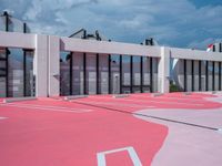 pink parking lot with white walls on the side of it and white line painted across each of them