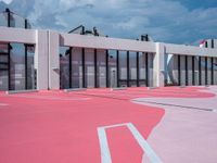 pink parking lot with white walls on the side of it and white line painted across each of them