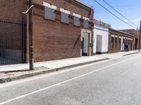 an empty street in a downtown area that includes brick buildings and several stairs in the corner