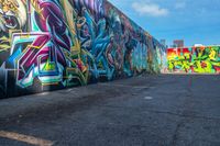 street art on the walls in a parking lot with tall buildings in the background and blue skies above