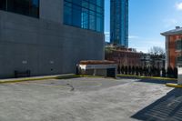 a clock is standing next to a parking garage and a building with windows on it