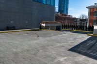 a clock is standing next to a parking garage and a building with windows on it