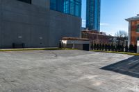 a clock is standing next to a parking garage and a building with windows on it