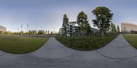 the view from within an outdoor sphere of a field with buildings in the background in a panorama