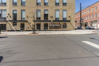 there is a large building on the corner of a street and a man riding a bike behind it