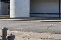 an old fire hydrant sitting next to a building on the side of the road