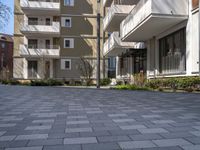 a man is walking in the yard next to a building with windows and balconys