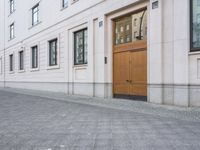 the brown door is set into the building's stucco wall in front of a wooden doorway