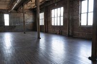an empty room with many windows next to it is painted dark brown and has wooden floors