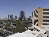 a city filled with tall buildings next to a highway under a blue sky overhead the street