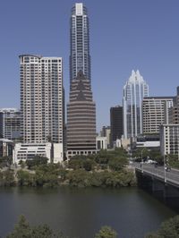 a city filled with tall buildings next to a highway under a blue sky overhead the street