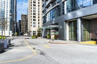 an empty parking lot between high - rise buildings and apartments with parking meters down