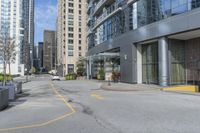 an empty parking lot between high - rise buildings and apartments with parking meters down