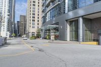 an empty parking lot between high - rise buildings and apartments with parking meters down