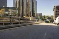 a truck on the road with tall buildings in the background while traffic is driving in opposite directions