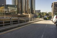 a truck on the road with tall buildings in the background while traffic is driving in opposite directions