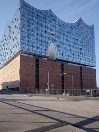 a big building with some windows next to a street corner and a few cars around it