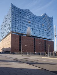 a big building with some windows next to a street corner and a few cars around it