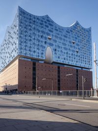 a big building with some windows next to a street corner and a few cars around it